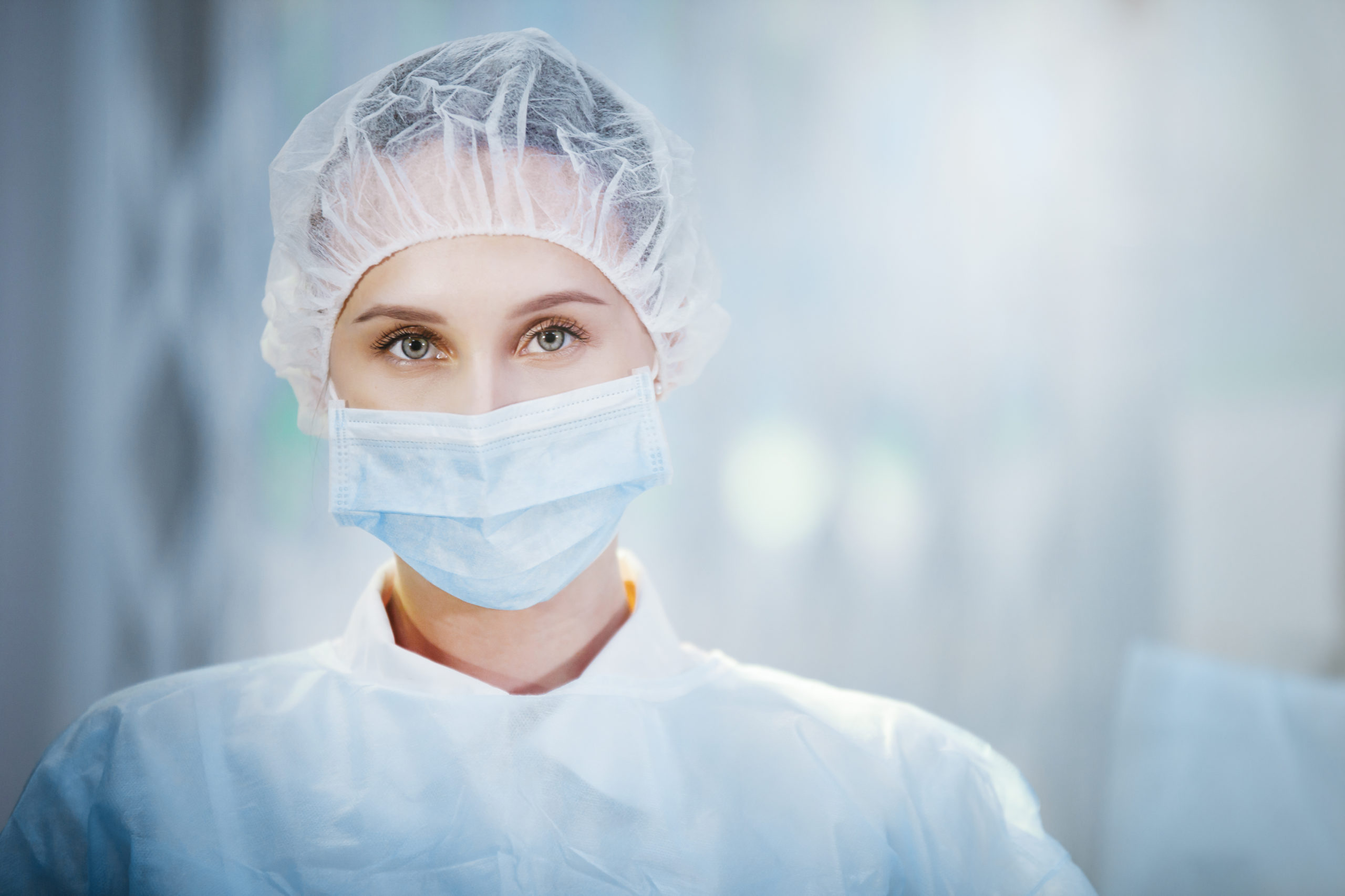 Surgical Nurse in cap and mask in medical clinic. Close-up portrait. Health care, surgery.