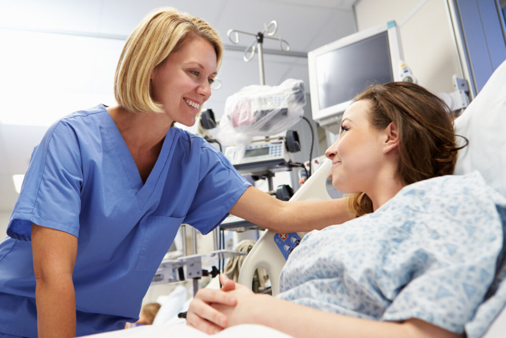 Young Female Patient Talking To Nurse In Emergency Room Young Female Patient Talking To Nurse In Emergency Room