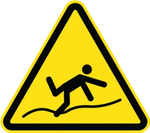 Yellow triangular warning sign with black border showing stick figure tripping over a wire