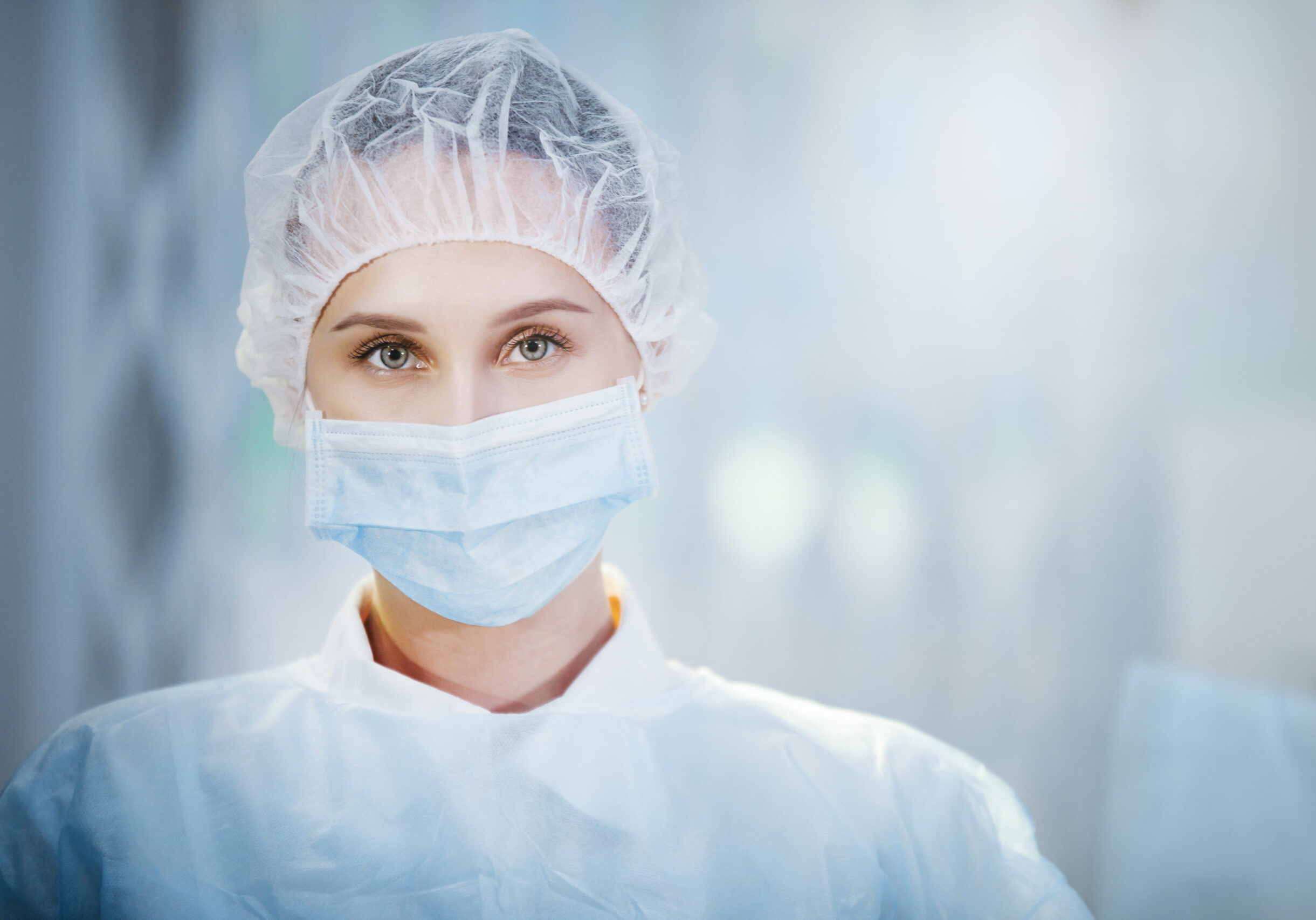 Surgical Nurse in cap and mask in medical clinic. Close-up portrait. Health care, surgery.